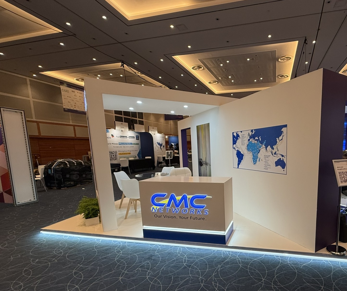 CMC Networks clean white exhibition booth with branded counters and wall graphics